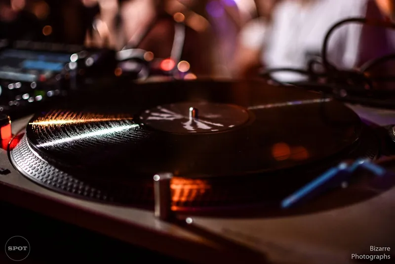 Bandeja de vinilo en primer plano con el público desenfocado detrás en The Spot